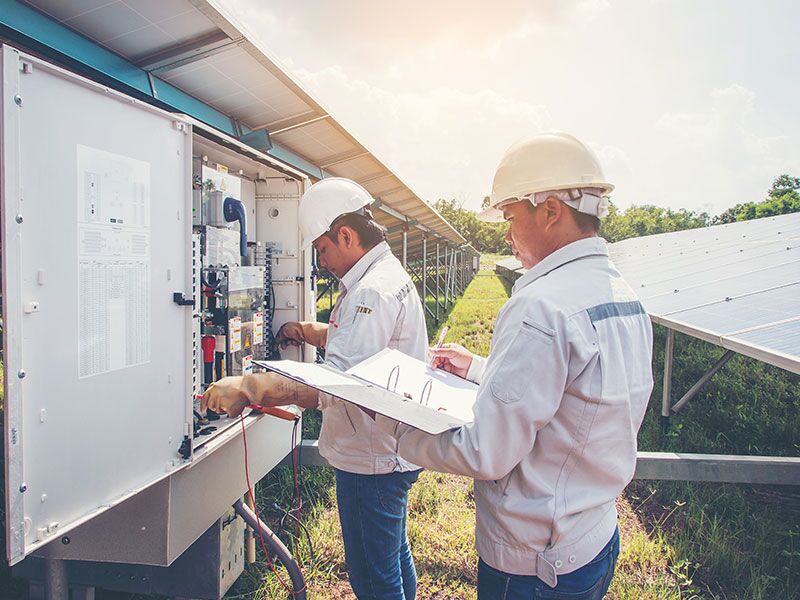 Custom Electrical empolyees outside doing electrical work for the building.