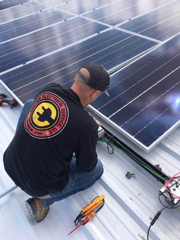 One Custom Electrical's commercial electrician in Utah installing a solar power unit on a building.