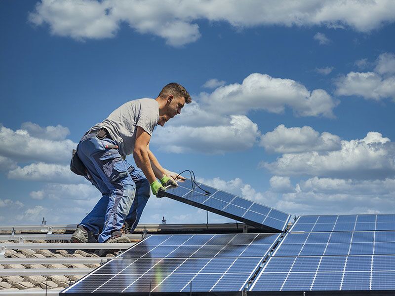 Service provider installing solar panels - service provided by Custom Electrical Services .